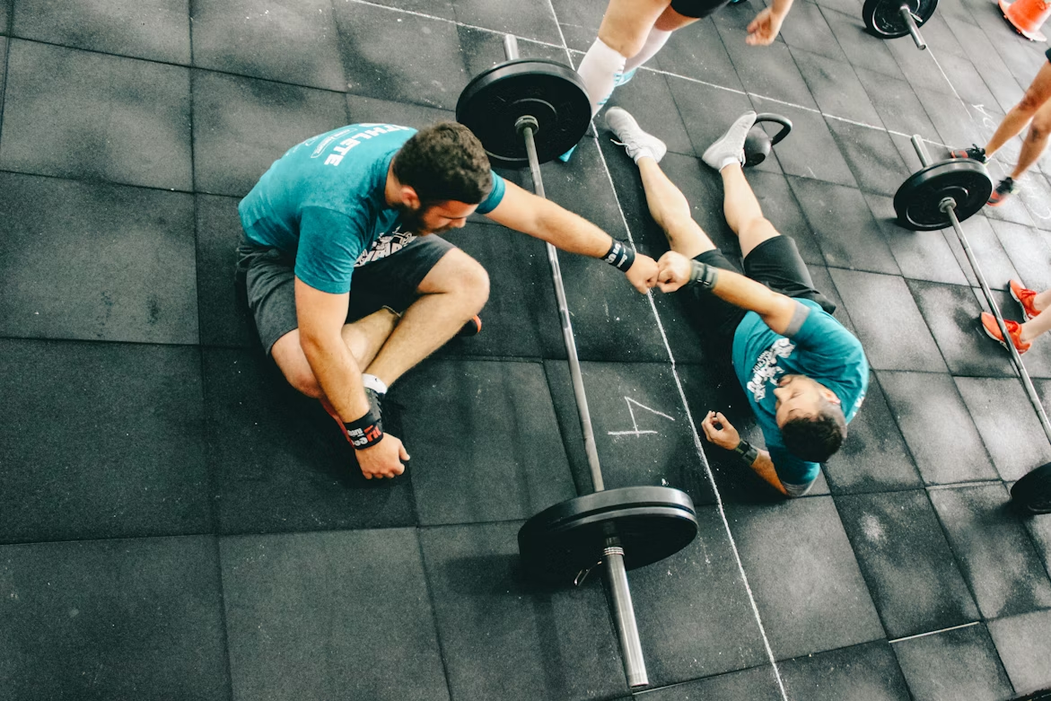 Two people fist bumping during a workout